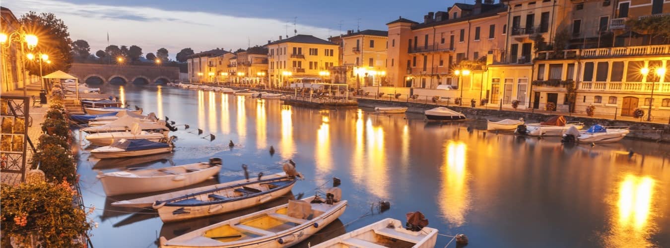 Italien Reiseziele - angelegte Boote am beleuchteten Gardasee